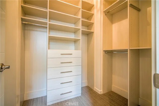 a view of walk in closet with empty racks
