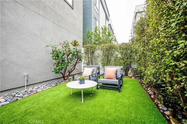a view of a chair and table in backyard of the house