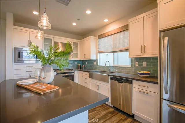 a kitchen with stainless steel appliances granite countertop a sink a stove and a refrigerator