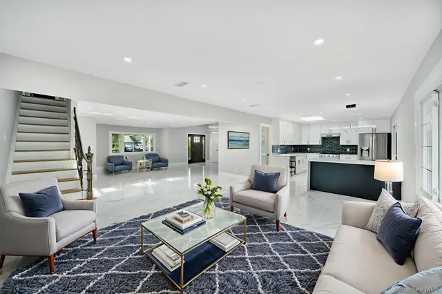 a living room with furniture and view of kitchen