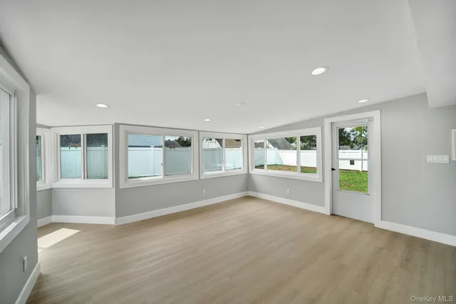 an empty room with wooden floor and a window