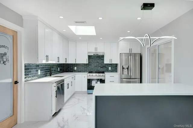 a kitchen with stainless steel appliances granite countertop a refrigerator and a stove top oven