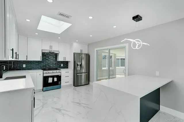 a kitchen with stainless steel appliances a refrigerator sink and microwave