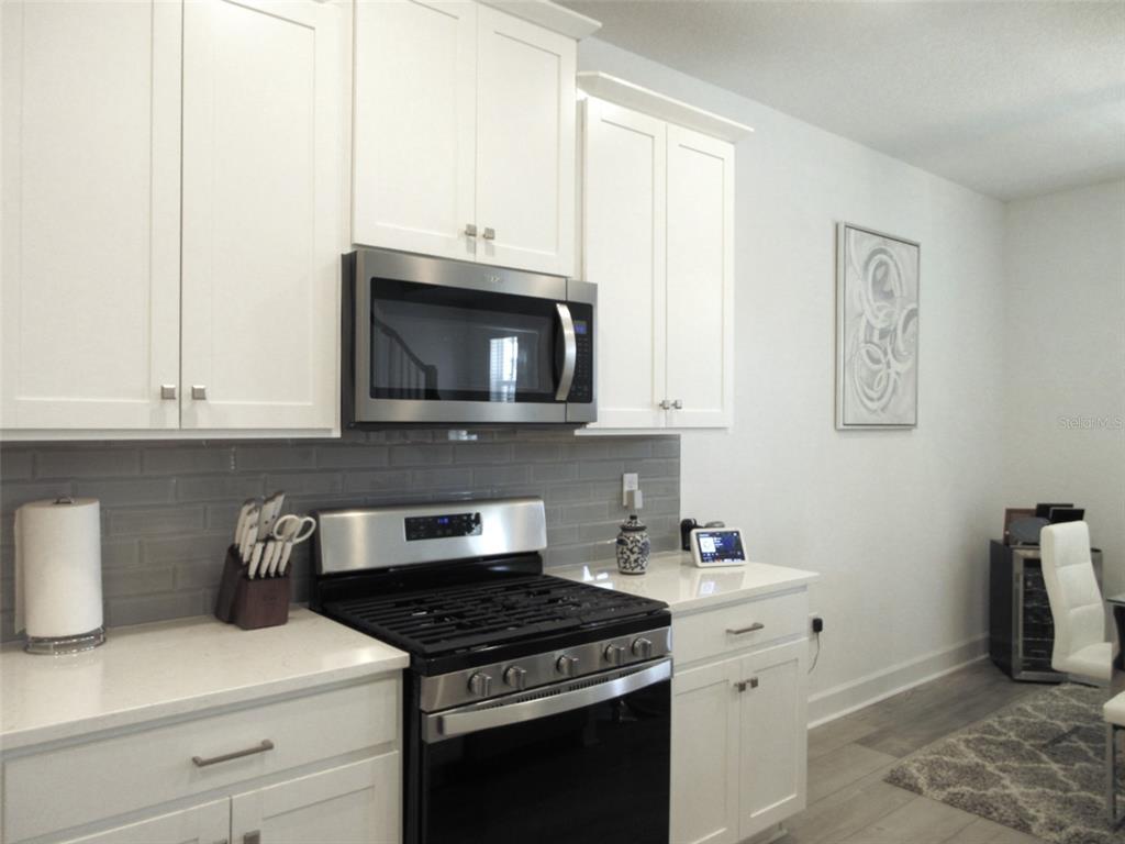 2252 Celebration Boulevard Celebration, FL 34747 - Photo 11 of 40 a kitchen with granite countertop white cabinets and black appliances