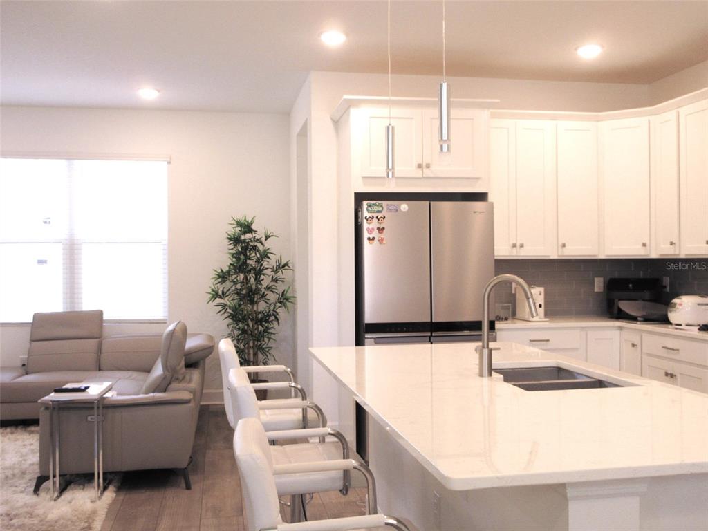 2252 Celebration Boulevard Celebration, FL 34747 - Photo 13 of 40 a kitchen with stainless steel appliances kitchen island granite countertop a sink and a white cabinets