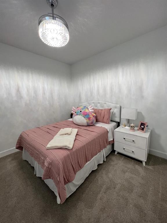 2252 Celebration Boulevard Celebration, FL 34747 - Photo 25 of 40 a spacious bedroom with a bed and chandelier