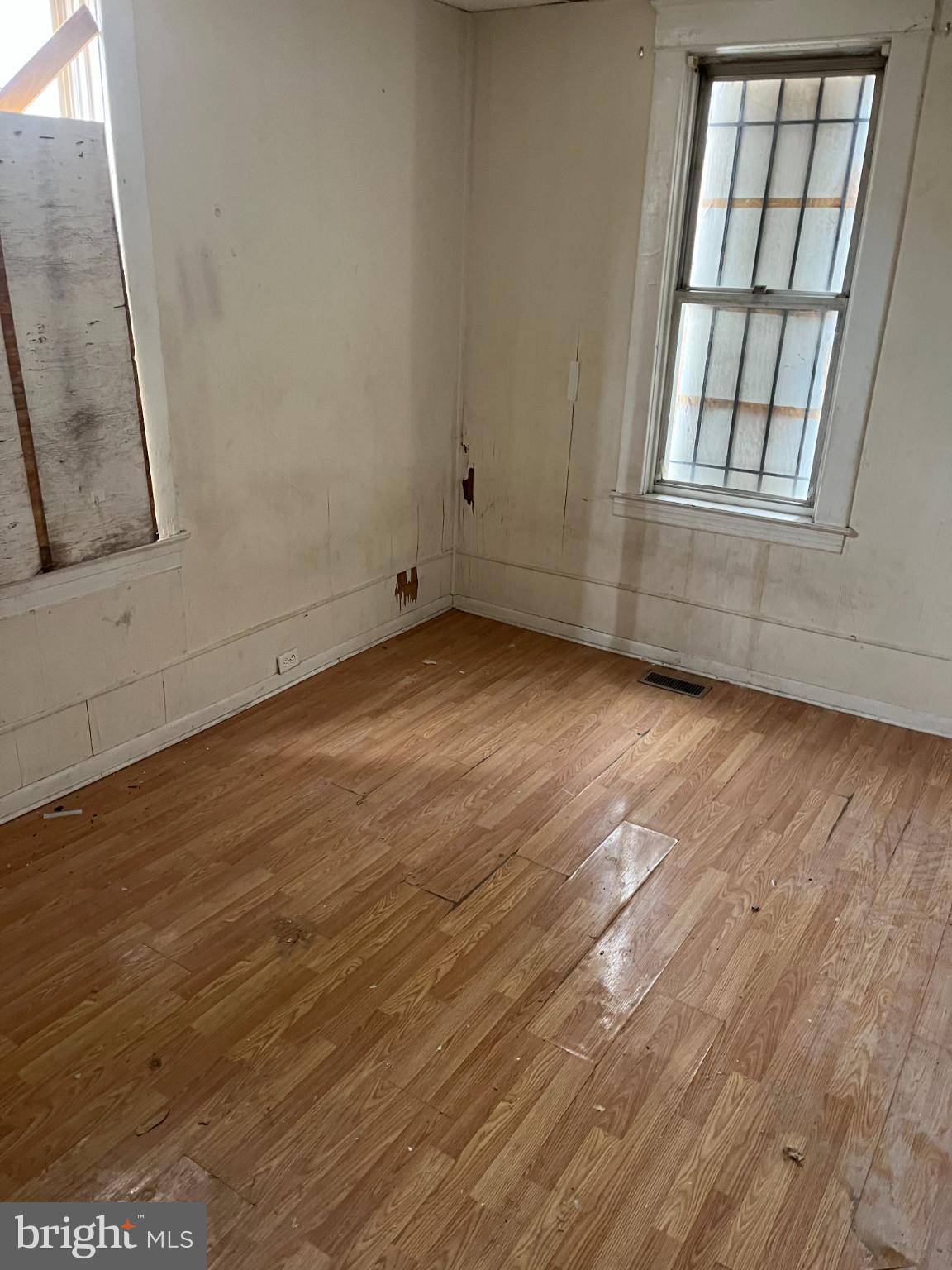 3601 9th Street Baltimore, MD 21225 - Photo 19 of 24 an empty room with wooden floor and windows