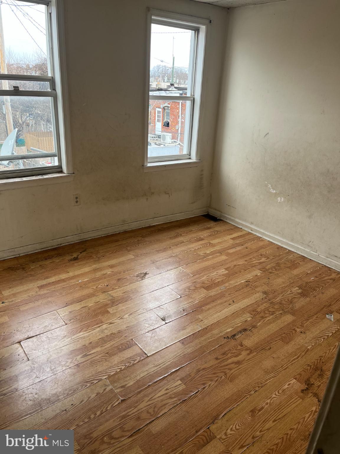 3601 9th Street Baltimore, MD 21225 - Photo 3 of 24 an empty room with wooden floor and windows