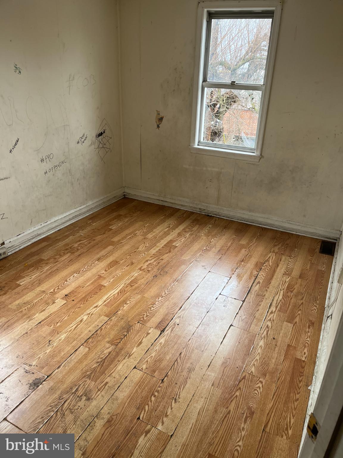 3601 9th Street Baltimore, MD 21225 - Photo 5 of 24 an empty room with wooden floor and windows