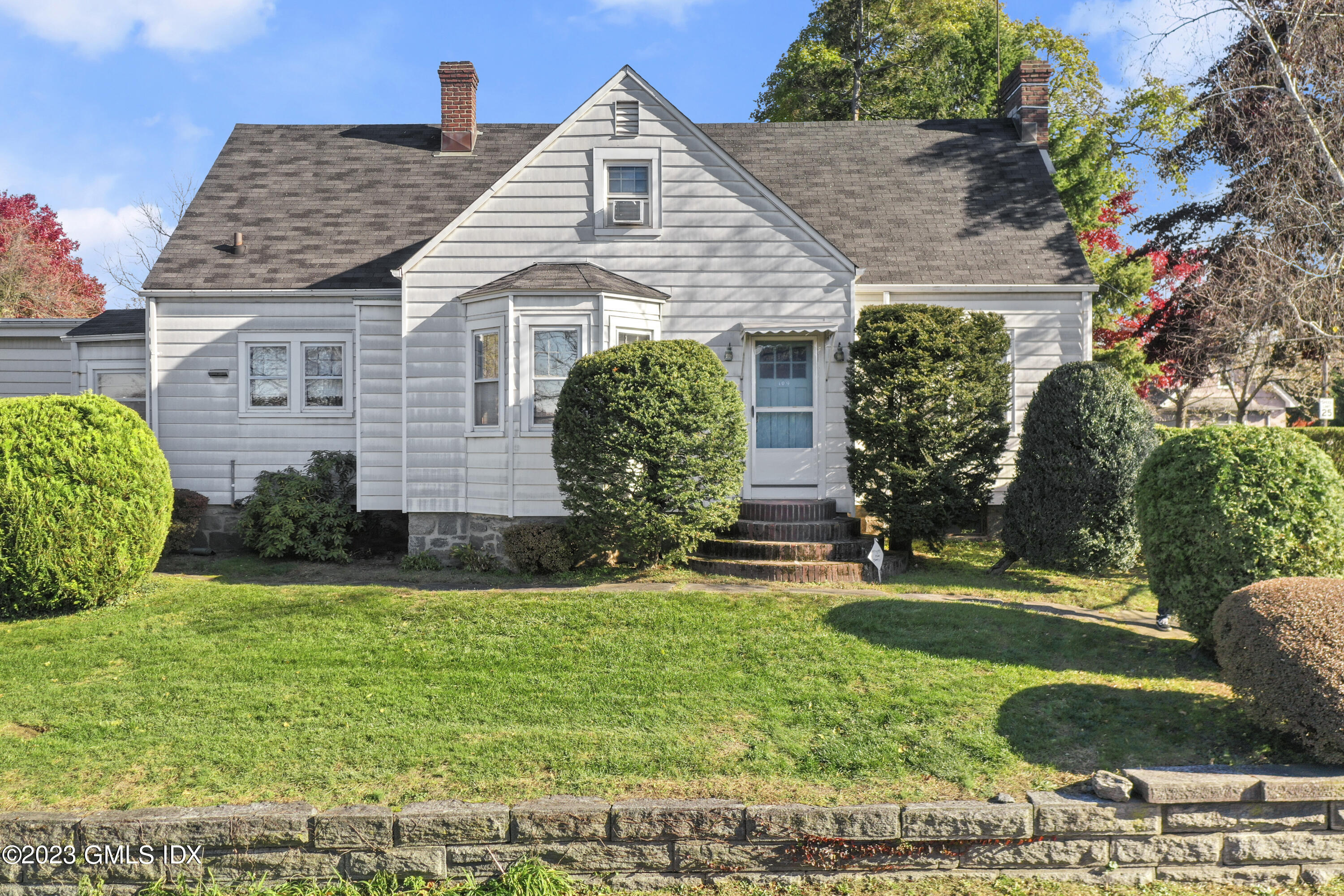 109 Byram Road Greenwich, CT 06830 - Photo 2 of 4 a front view of a house with a garden