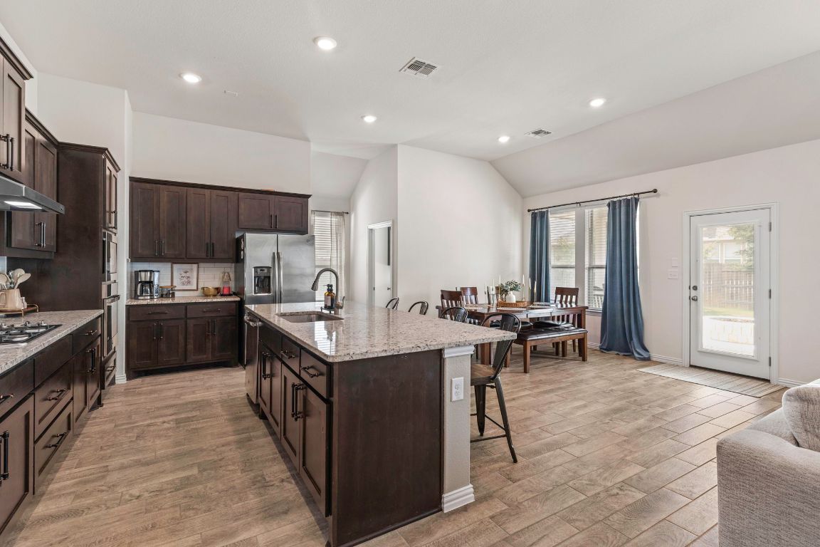 232 Silver Pass Kyle, TX 78640 - Photo 16 of 39 The heart of the home shines with seamless flow from the oversized island to the living and dining spaces. Granite counters, espresso cabinets, and stylish lighting elevate the entire feel.