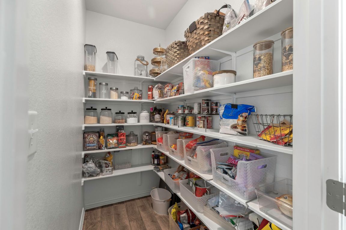 232 Silver Pass Kyle, TX 78640 - Photo 19 of 39 Pantry Goals! Okay yes, it’s full but that just proves how spacious it really is! With wall-to-wall shelving, deep storage, and plenty of room for snacks (and backup snacks), this walk-in pantry is every home cook’s dream. Whether you’re a meal prepper, snack hoarder, or just hiding the Halloween candy from the kids,this pantry’s got your back.