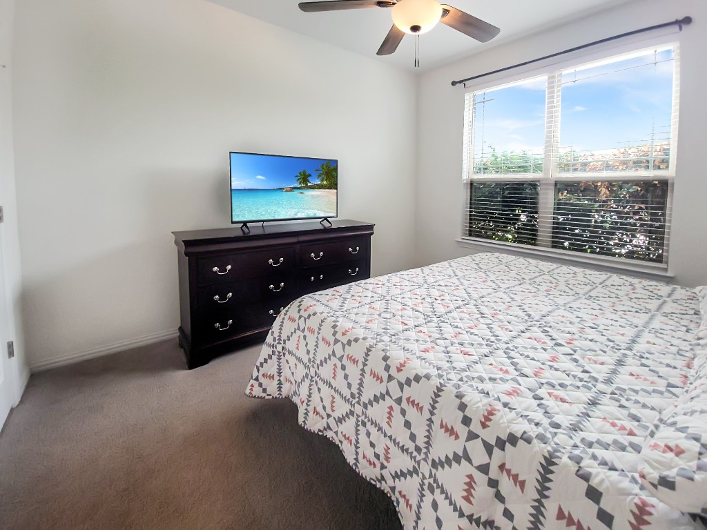 232 Silver Pass Kyle, TX 78640 - Photo 30 of 39 secondary bedrooms offer a quiet retreat away from the primary suite. Each features abundant natural light, upgraded ceiling fans, and spacious walk-in closets. Conveniently located near a dedicated full bath, perfect for guests or family.