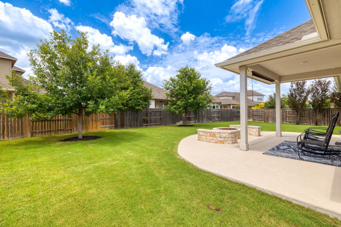 232 Silver Pass Kyle, TX 78640 - Photo 32 of 39 Enjoy cozy nights and breezy afternoons under this extended covered patio, complete with built-in seating and a gas line for your dream grill setup.