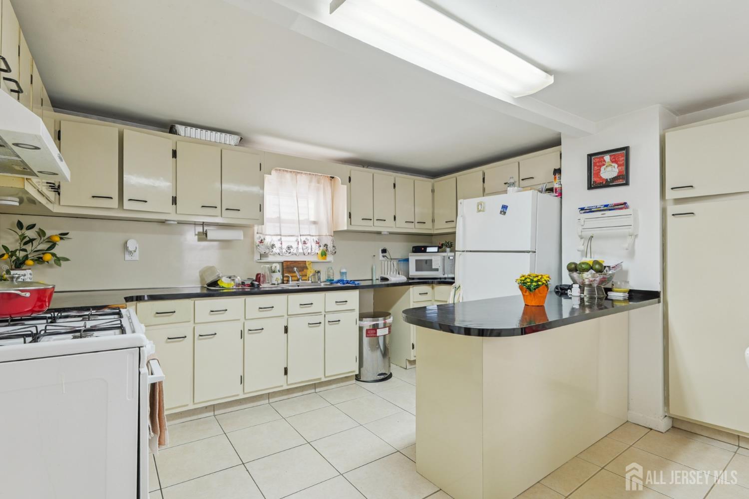 655 Charles Street Perth Amboy, NJ 08861 - Photo 21 of 29 a kitchen with cabinets a sink and white appliances