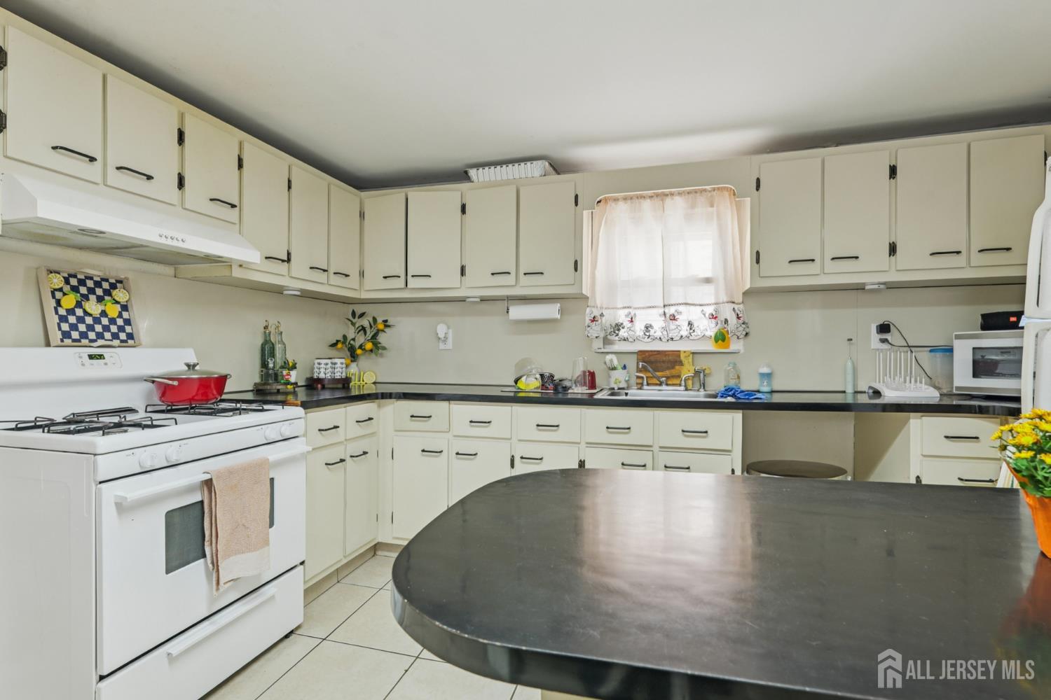 655 Charles Street Perth Amboy, NJ 08861 - Photo 22 of 29 a kitchen with granite countertop white cabinets and white appliances