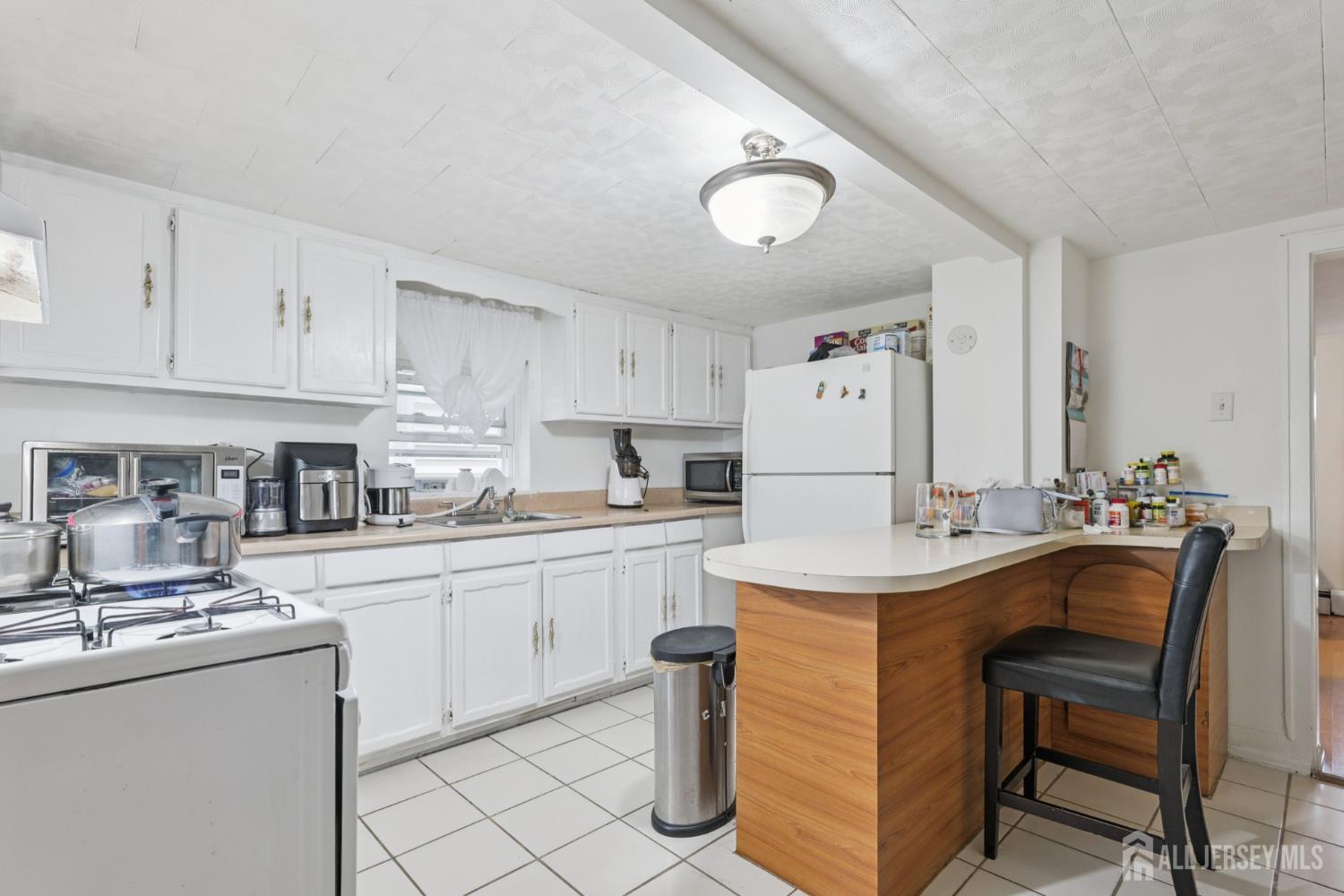 655 Charles Street Perth Amboy, NJ 08861 - Photo 5 of 29 a kitchen with kitchen island a sink table and chairs