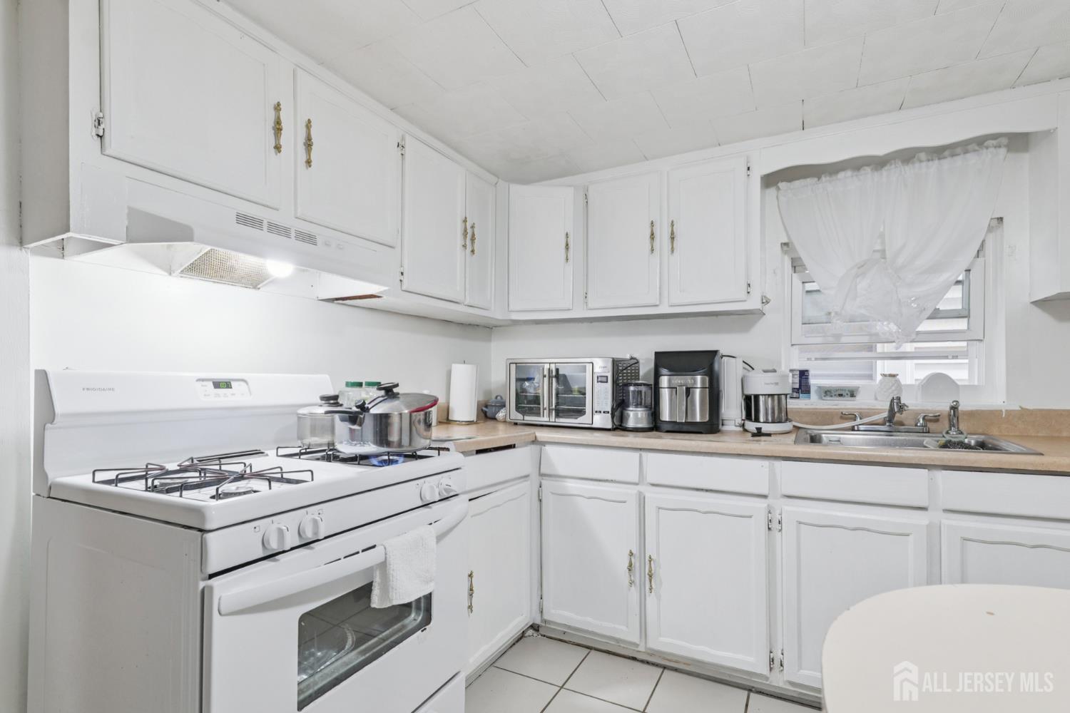 655 Charles Street Perth Amboy, NJ 08861 - Photo 6 of 29 a kitchen with granite countertop cabinets and white appliances