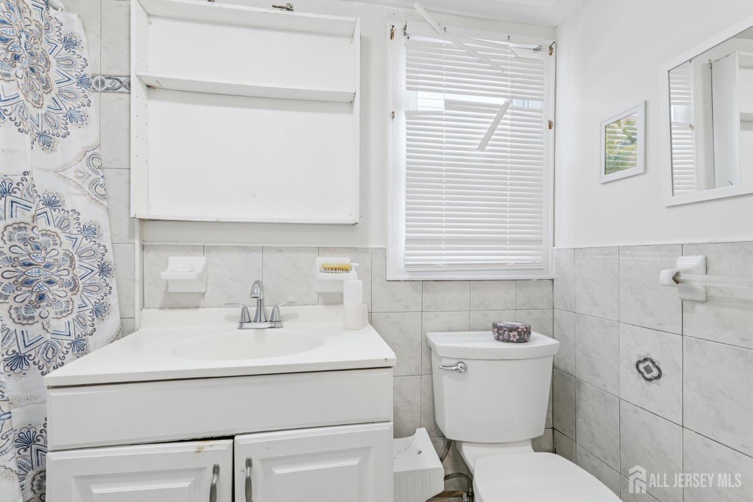 655 Charles Street Perth Amboy, NJ 08861 - Photo 8 of 29 a bathroom with a sink toilet and mirror