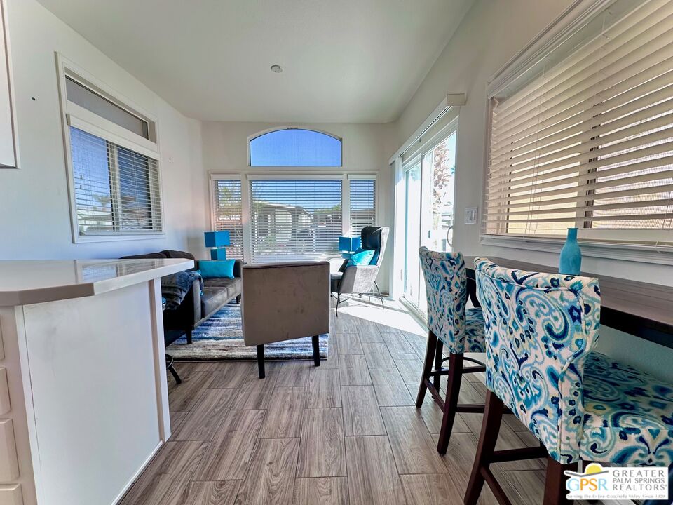 69801 Ramon Road, Unit 228 Cathedral City, CA 92234 - Photo 3 of 12 a view of a dining room with furniture and wooden floor