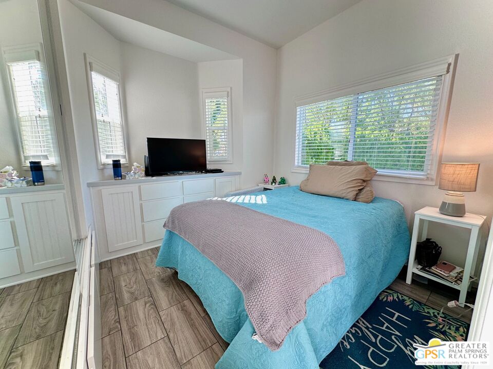 69801 Ramon Road, Unit 228 Cathedral City, CA 92234 - Photo 6 of 12 a bedroom with a bed and a flat screen tv