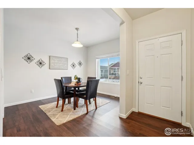 a dining room with furniture a chandelier and wooden floor