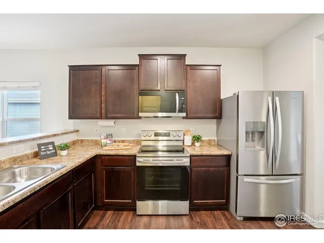 a kitchen with a sink a refrigerator a stove and cabinets