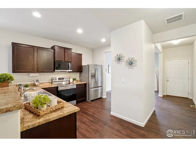 a kitchen with refrigerator cabinets and wooden floor