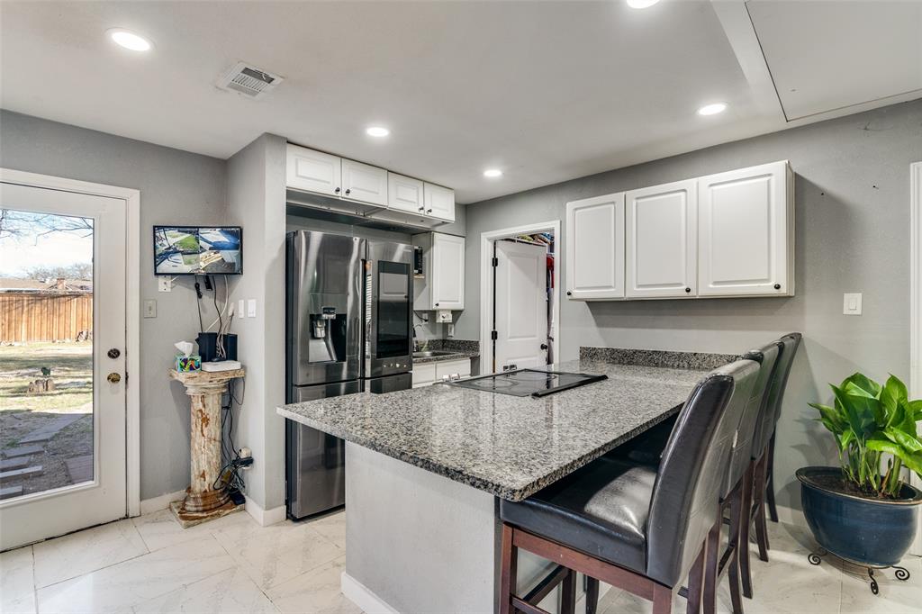 650 Pleasant Oaks Drive Dallas, TX 75217 - Photo 11 of 25 a kitchen with granite countertop kitchen island a counter space and stainless steel appliances