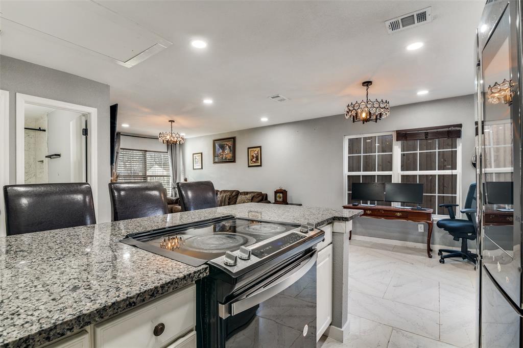 650 Pleasant Oaks Drive Dallas, TX 75217 - Photo 14 of 25 a kitchen island with granite countertop a table and chairs