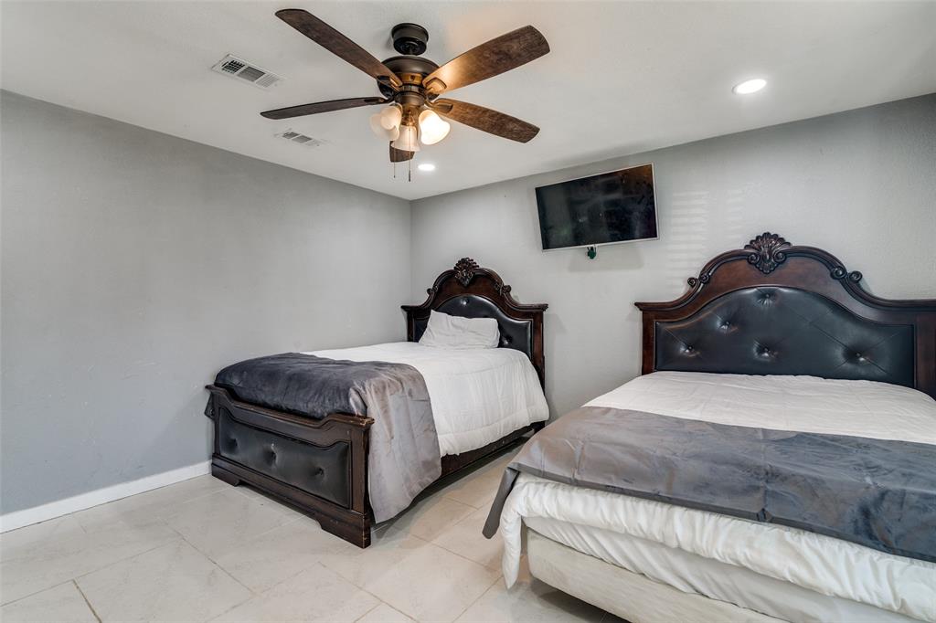 650 Pleasant Oaks Drive Dallas, TX 75217 - Photo 16 of 25 a bedroom with two separate beds and a flat screen tv