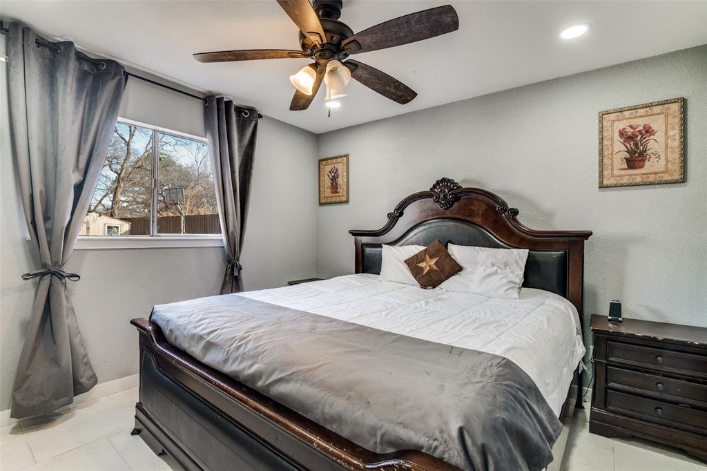 650 Pleasant Oaks Drive Dallas, TX 75217 - Photo 18 of 25 a bedroom with a bed and a large window