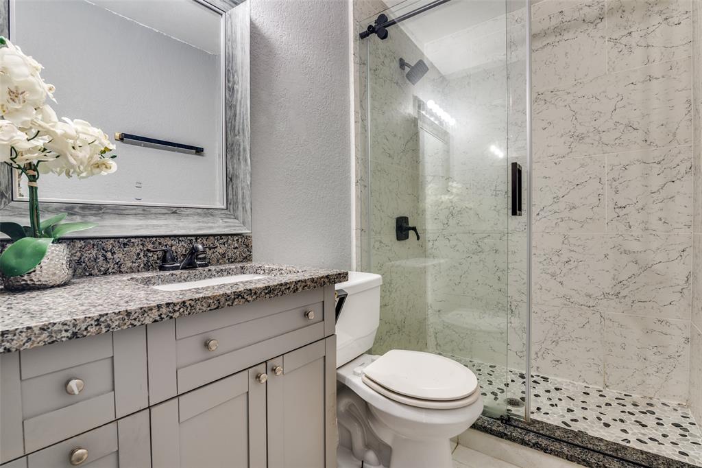 650 Pleasant Oaks Drive Dallas, TX 75217 - Photo 19 of 25 a bathroom with a granite countertop sink toilet and shower