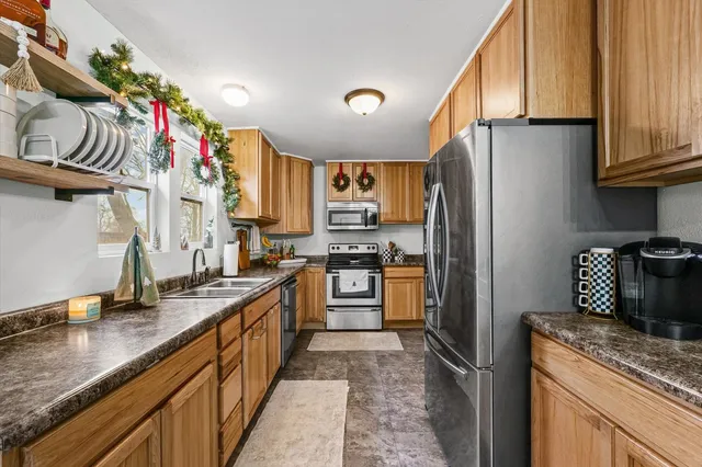 a kitchen with granite countertop a refrigerator stove and sink