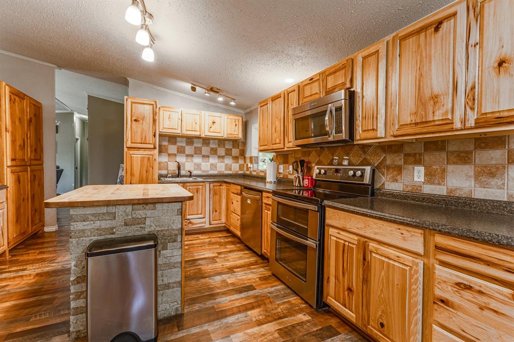 75 Southern Road Mineral Wells, TX 76067 - Photo 6 of 31 a kitchen with stainless steel appliances granite countertop a stove sink and cabinets
