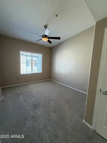an empty room with a ceiling fan and fan