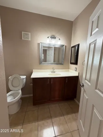 a bathroom with a sink a toilet and a large mirror