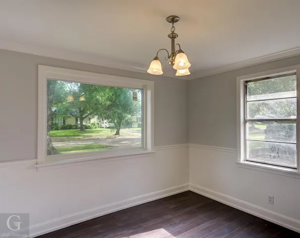 a view of empty room with wooden floor and windows