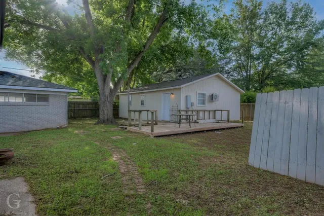 a view of a house with a yard and deck