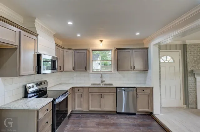 a kitchen with stainless steel appliances granite countertop a sink stove and cabinets