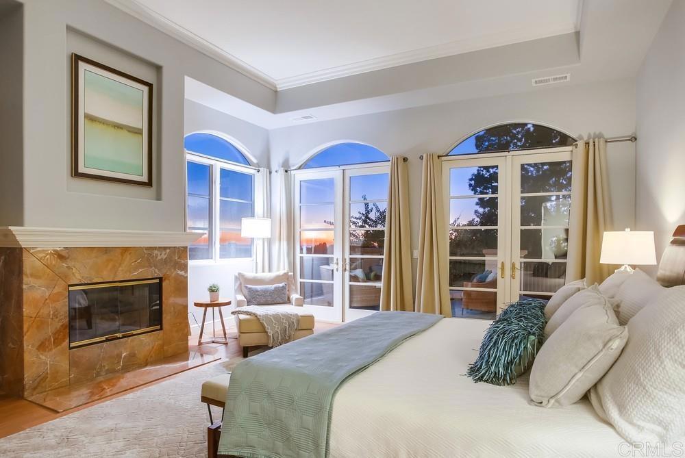 7180 Aviara Drive Carlsbad, CA 92011 - Photo 26 of 43 a bedroom with a bed a fireplace and a large window