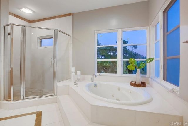 a spacious bedroom with a large bed and a chandelier