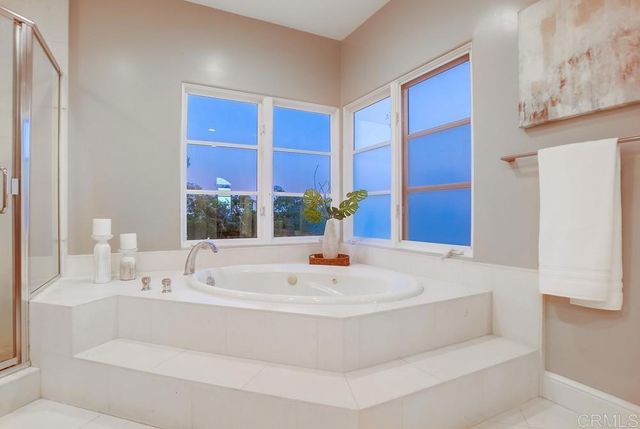 a bathroom with a tub sink and mirror