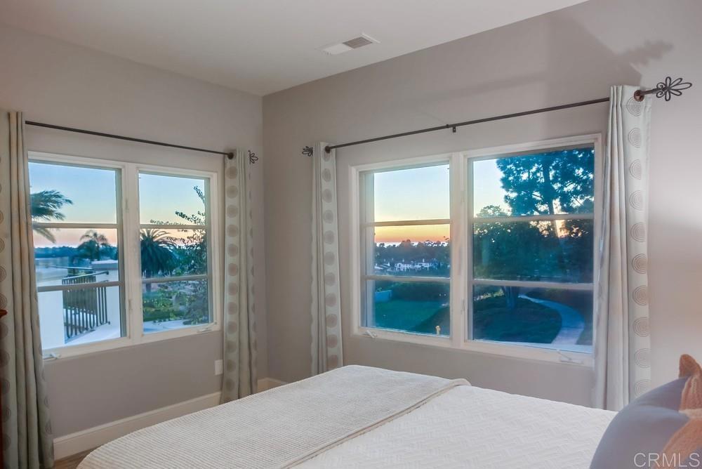 7180 Aviara Drive Carlsbad, CA 92011 - Photo 40 of 43 a bedroom with a large window and a bed