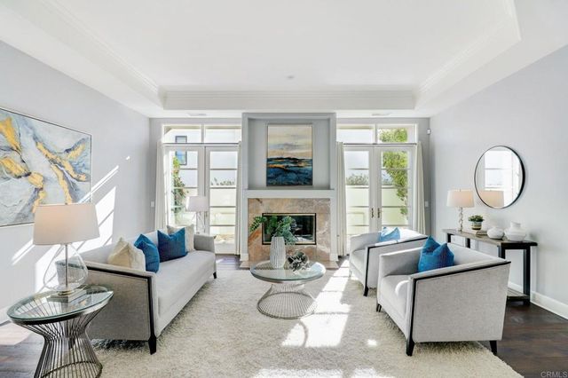 a living room with furniture a fireplace and a large window with balcony view