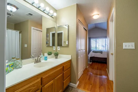 a en suite spacious bathroom with a granite countertop double vanity sink a mirror and a shower