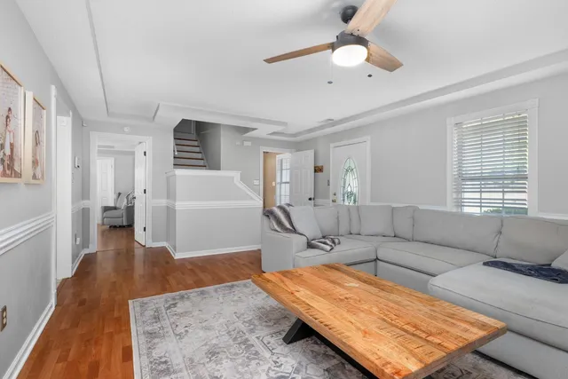 a living room with furniture and a wooden floor