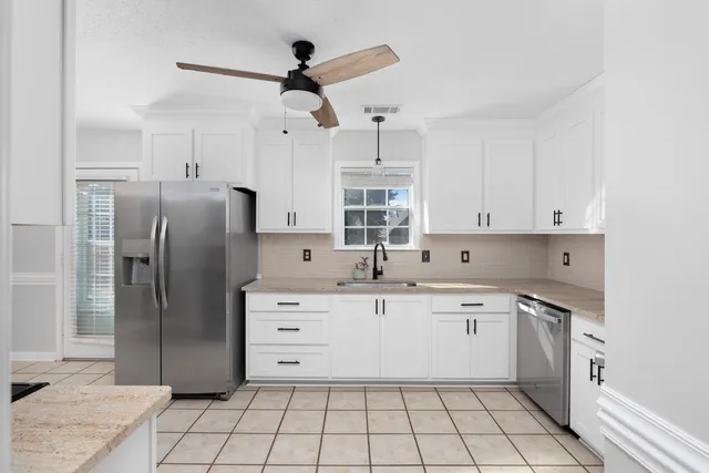 a kitchen with stainless steel appliances a refrigerator sink and cabinets