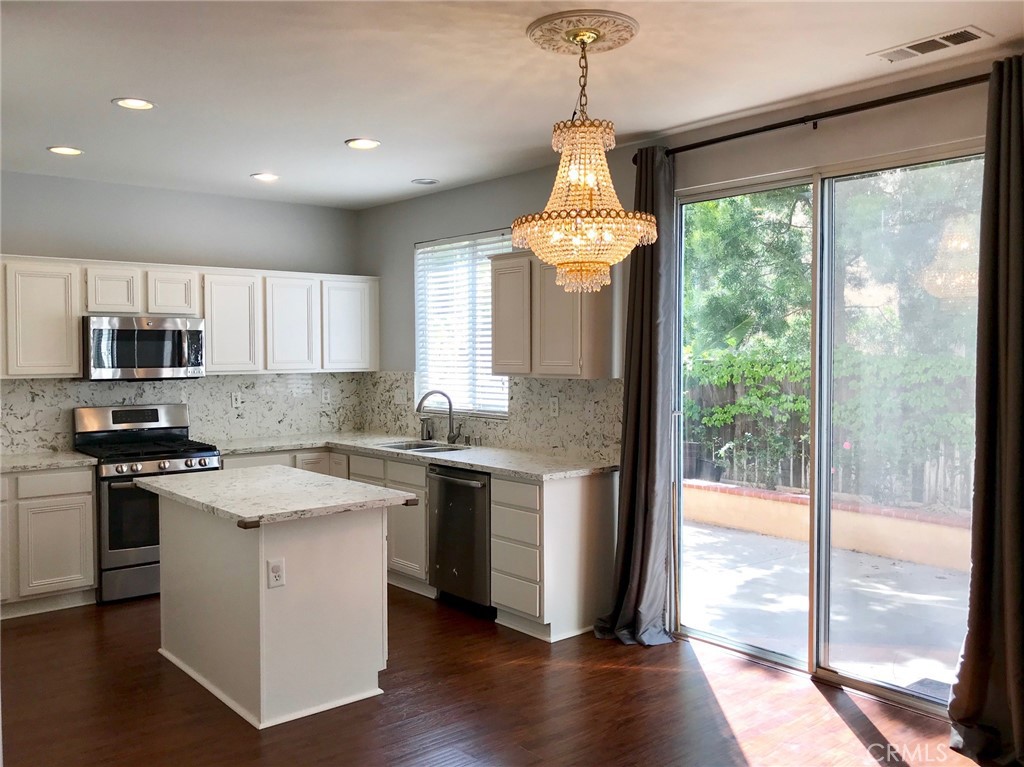 15 Brookhollow Irvine, CA 92602 - Photo 3 of 8 a kitchen with stainless steel appliances granite countertop a stove a sink a refrigerator and a wooden floor