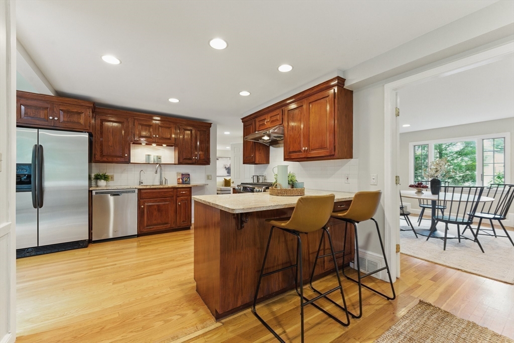 6 Willow Park Wellesley, MA 02481 - Photo 9 of 37 a kitchen with stainless steel appliances granite countertop a table chairs sink refrigerator and microwave